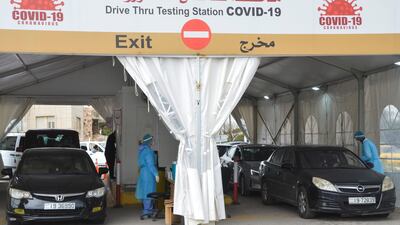 People wait inside their vehicles to get tested for coronavirus disease at a drive-through testing station in Amman, Jordan. Reuters