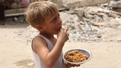 A boy with a meal provided by a charity kitchen in Gaza city. Israel has blocked aid to the Gaza Strip since March. AFP