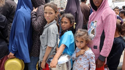 Palestinians queue at a food distribution point in a displacement camp near Gaza City's port on Thursday. AFP