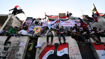 Protesters stand on concrete blocks which are used by security forces to block the Al Jumhuriya bridge. EPA