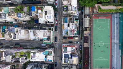 People playing football at a park next to houses.