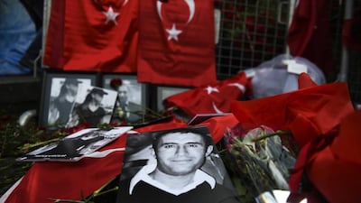 Victims of the New Year’s Day massacre in Istanbul are pictured alongside Turkish flags and flowers lain outside the Reina nightclub, where 39 people were shot dead, 20 of them Arab tourists. Bulent Kilic / AFP
