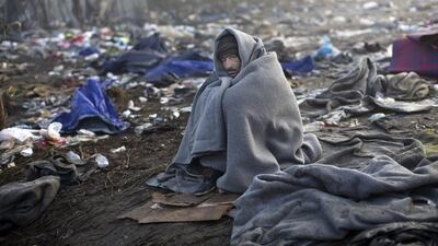 A man stays warm by wrapping himself in a blanket as he waits to cross Serbia's border with Croatia in Berkasovo on October 24, 2015. Marko Drobnjakovic/AP Photo