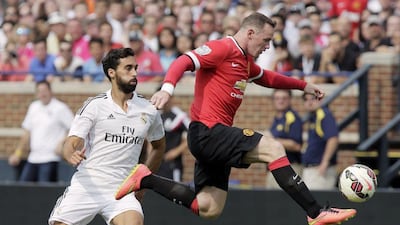 Wayne Rooney of Manchester United, right, leaps in the air to control the ball against Alvaro Arbeloa, left, of Real Madrid during their match on Saturday at Michigan Stadium. Duane Burleson / Getty Images / AFP