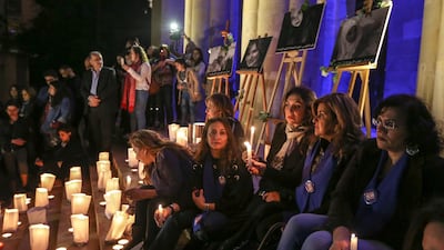 Lebanese activists carry candles in front of pictures depicting British embassy worker Rebecca Dykes and three Lebanese women during a sit-in in front of the national museum in Beirut on December 23, 2017. Nabil Mounzer / EPA