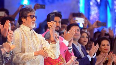 Indian Bollywood actor Amitabh Bachchan (L) photographs his daughter Shweta Nanda Bachchan as she showcases creations by designer Abu Jani Sandeep Khosla during a fashion show in Mumbai on late November 4, 2016. / AFP / STR