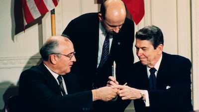 Reagan and Gorbachev exchange pens during the treaty-signing ceremony at the White House. AP