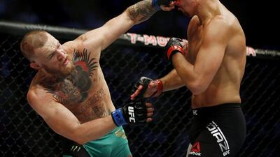 Conor McGregor punches Nate Diaz during their welterweight bout at UFC 202 on August 20, 2016, in Las Vegas.