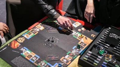 People playing the Al Maseera board game, which is similar to Monopoly.