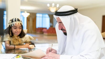 Rayan Al Khori watches as Sharjah Ruler, Sheikh Dr Sultan bin Muhammad Al Qasimi signs certificates in the palace. Courtesy: Sheikh Dr Sultan / Instagram