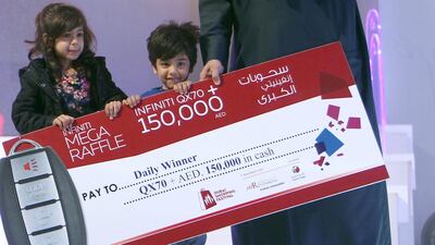 Three-year-old Talal Al Hammar accepts his reward for winning the Dubai Shopping Festival raffle. Courtesy Dubai Tourism