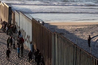 Central American migrants moving towards the United States in hopes of a better life, stand by the US-Mexico border fence in Playas de Tijuana, Mexico. AFP