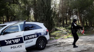 An Israeli police officer seals off the area where the body of an Israeli woman was found in Jerusalem. AP