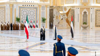 Sheikh Mohamed and Sheikh Meshal stand for their national anthems at Qasr Al Watan. Abdulla Al Bedwawi / UAE Presidential Court