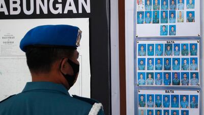 A military officer looks at the pictures of crew members of the missing Indonesian Navy submarine KRI Nanggala. EPA