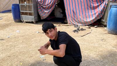 Murtadha Riyadh, 19, splashes cold water on his face to beat the heat outside the tent he and others sleep in.