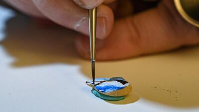 Hasan Kale paints on a broad bean in Istanbul