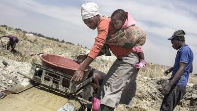 Illegal miners in Springs, near Johannesburg, sift through mounds of disused stone to find gold dust. John Wessels / AFP