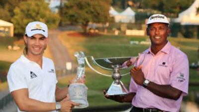 Camilo Villegas, left, holds The Tour Championship trophy while Vijay Singh smiles with the FedExCup trophy after the final round of The Tour Championship at East Lake Golf Club.