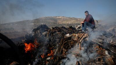 Palestinian Yahya Dalal, 32, sits near cars burnt in an attack by Israeli settlers, in Huwara, in the occupied West Bank. Reuters