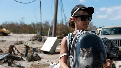 Kate Frank and her cat make their way to a boat to be moved from the island on Tuesday. Getty / AFP