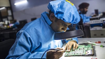 An employee repairs a circuit board in the electronics section at the refurbishment facility of GreenDust. Prashanth Vishwanathan / Bloomberg