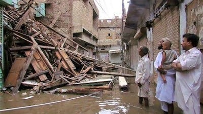 Pakistani residents look at a collapsed house caused by torrential rain in Sukkur yesterday.
