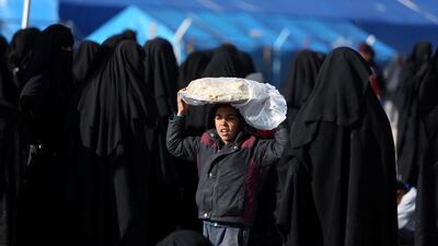 A boy carries bread on his head at AL Hol displacement camp in Hasaka governorate, Syria April 2, 2019. Reuters