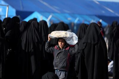 A boy carries bread on his head at AL Hol displacement camp in Hasaka governorate, Syria April 2, 2019. Reuters