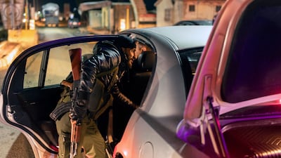 Members of the security forces of the newly formed Syrian government inspect vehicles at a security checkpoint on the Syrian border with Lebanon. AP