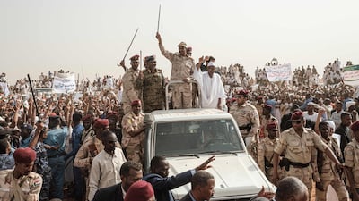 Mohamed Hamdan Dagalo (C), known as Himediti, deputy head of Sudan's ruling Transitional Military Council (TMC) and commander of the Rapid Support Forces (RSF) paramilitaries, waves a baton to supporters on a vehicle as he arrives for a rally in the village of Abraq. AFP