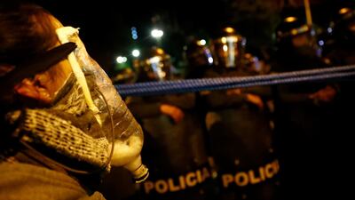 A protester with self-made gas mask confronts riot police during a march in La Paz, Bolivia. Reuters