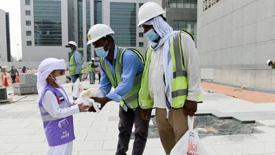 Mubarak Saeed Al Mazrouei, 5, a young Emirati volunteer hands out food to construction workers, as part of the initiative by the Supreme Council of Motherhood and Childhood, in Abu Dhabi. All photos: Khushnum Bhandari / The National