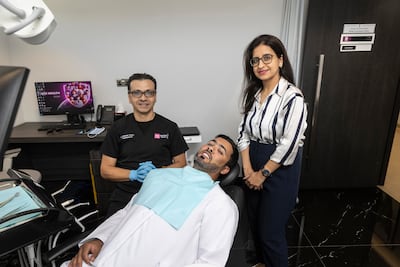 Juma Almheiri with Drs Saman Fallahi and Divya Raigangar during work to fully restore his mouth. Antonie Robertson/The National