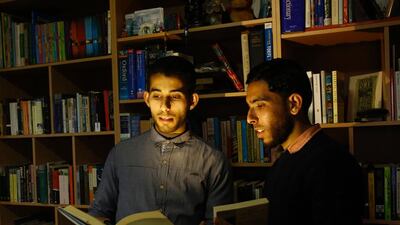 Mossab Abu Toha, left, and his friend Shafi Salem, who is helping Abu Toha set up the "Library and Bookshop for Gaza" project in Mr Abu Toha's family home in Beit Lahia in northern Gaza on February 20, 2017. Mr Abu Toha is struggling to open the first English-language library in the beleaguered Palestinian territory. Mohammed Abed/AFP