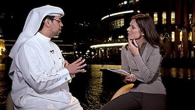 Erin Burnett, the business anchor at the US cable news channel CNBC, interviews Hamad Buamim, the director general of the Dubai Chamber of Commerce, during her evening broadcast this month near the Dubai Mall fountain.