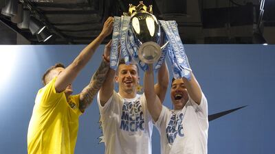 Manchester City players Samir Nasri, right, Stevan Jovetic, centre, and Matija Nastasic, left, lift the Premier League trophy during their appearance at Marina Mall in Abu Dhabi on Tuesday. Mona Al-Marzooqi / The National / May 13, 2014