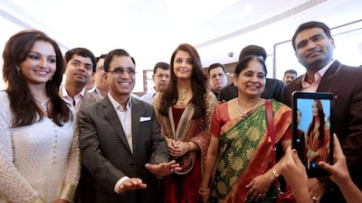 TS Kalyanaraman, centre left, of Kalyan Jewellers, with actresses Manju Warrier, left, and Aishwarya Rai Bachchan, centre. Christopher Pike / The National