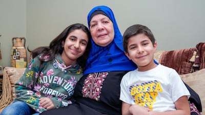 Samiha Ahmed, who is in recovery from lung cancer, pictured at home in Abu Dhabi with grandchildren Tasneem, 11 and Marwan, 8. Victor Besa / The National