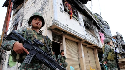 Government soldiers stand guard in front of damaged building and houses in Sultan Omar Dianalan boulevard at Mapandi district in Marawi city, southern Philippines. Romeo Ranoco / Reuters