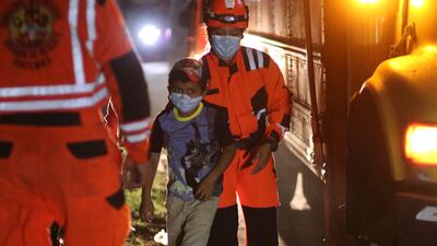 Handout picture released by Bomberos Volutarios shows Firefighters help evacuees settle in a temporary shelter in Santa Lucia Cotzumalguapa south Guatemala City. Some 370 people from a community based at the base of the Fuego volcano, in southwestern Guatemala, were evacuated on Monday following the increase in the volcanic activity of the colossus, the Civil Protection Agency reported. AFP