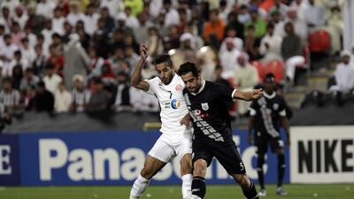 Ali Mabkhout ( no 7 of Al Jazira in white ) and Morteza Pouraliganji ( no 5 of Al Sadd in black ) at their ongoing AFC football match. ( Jeffrey E Biteng / The National