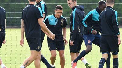 Arsenal's Alexis Sanchez and teammates run drills during their training session on Monday ahead of their match against Olympiakos on Tuesday in the Champions League. Andy Rain / EPA