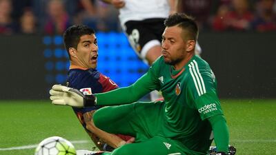 Barcelona’s Uruguayan forward Luis Suarez (L) vies with Valencia’s goalkeeper Diego Alves. Lluis Gene / AFP