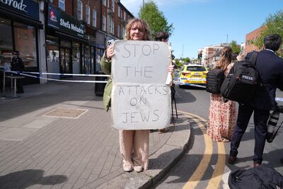 A person holds a placard at the scene. PA