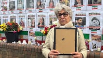 Azam, an Iranian woman living in the UK, hung the photo of a young man who was killed, at a memorial in London for protesters who died. Lemma Shehadi / The National