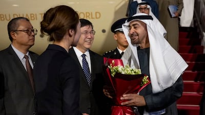 Sheikh Mohamed is presented with flowers by a member of the Chinese delegation.