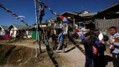 Buddhist volunteers hang prayer flags in Tawang yesterday to prepare for the Dalai Lama's visit.