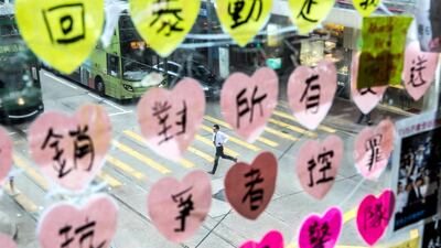 A man runs past post-it notes which form part of a Lennon Wall in Central Hong Kong. Lennon Walls are area designated to posters, art and messages in support of the pro-democracy movement.