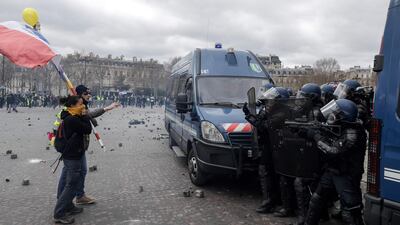 Yellow-vest protesters holding a French national flag argue with riot police on the Place de l'Etoile in Paris on March 16, 2019. AFP